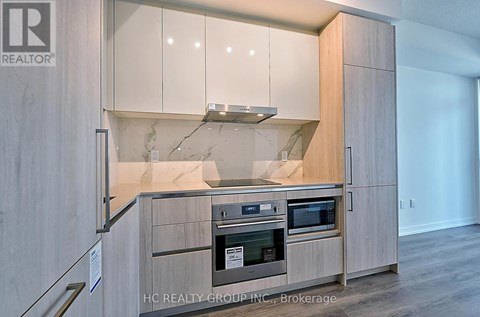 A modern kitchen with wooden cabinets and stainless steel appliances.