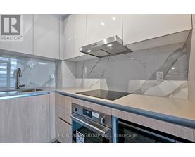 A modern kitchen with a stainless steel oven and a marble backsplash.