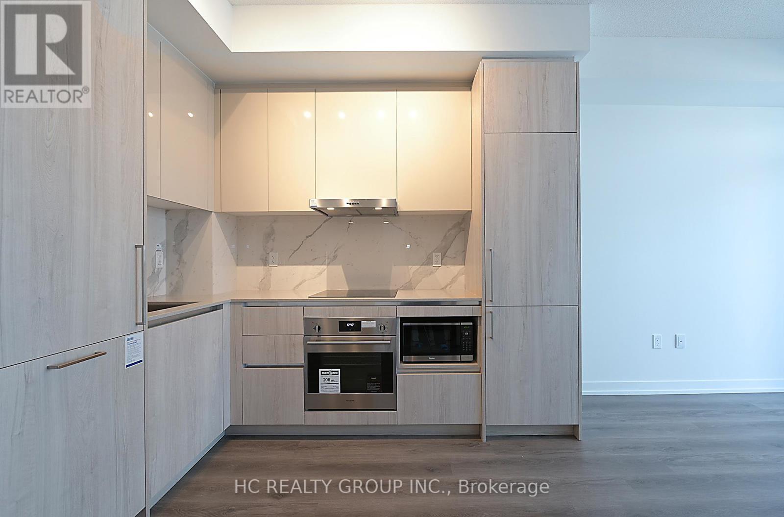 A modern kitchen with wooden cabinets and a built-in oven.