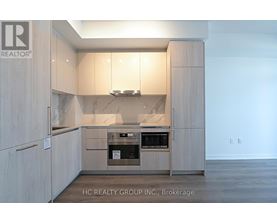 A modern kitchen with wooden cabinets and a built-in oven.