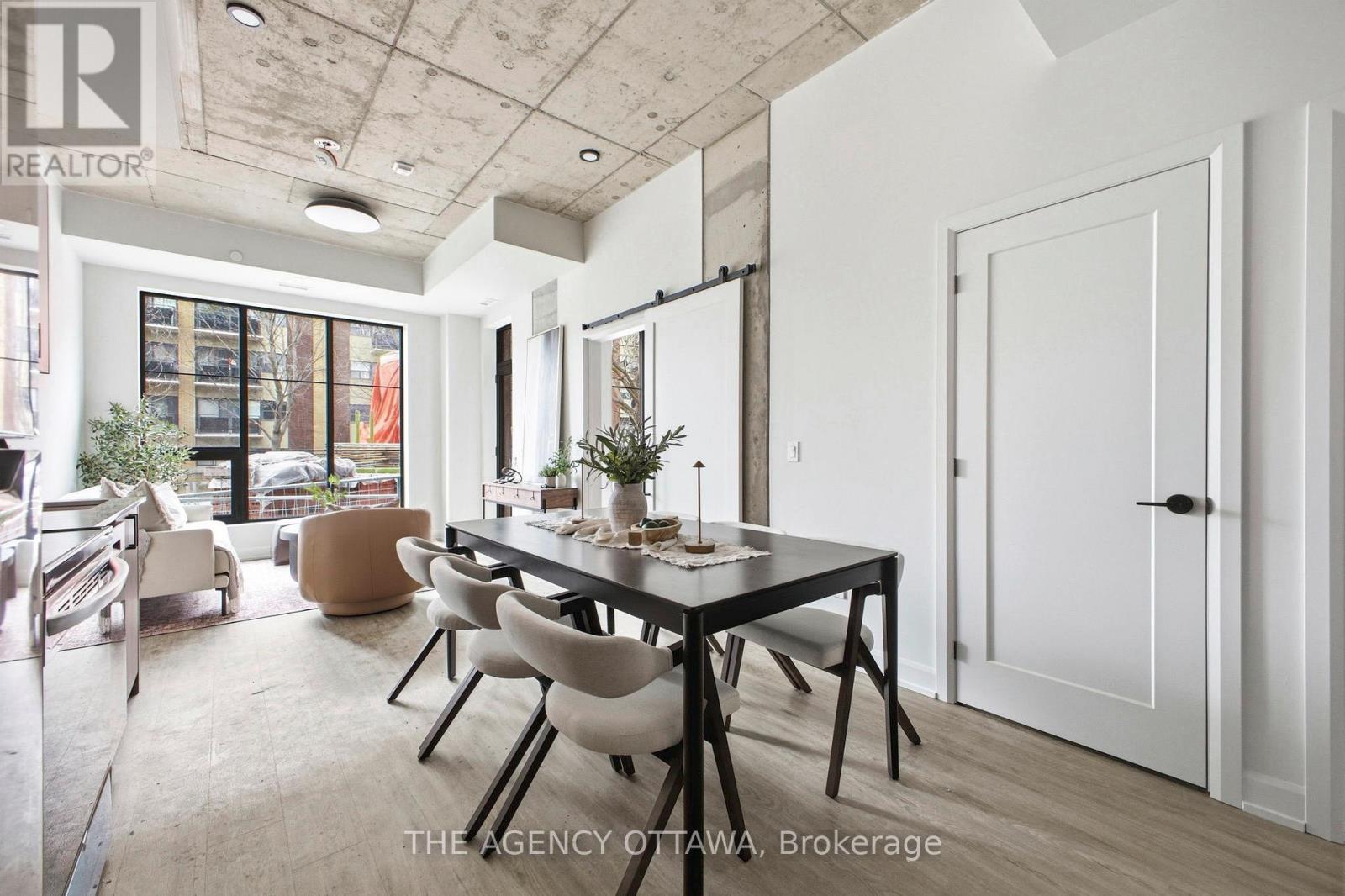 A dining room with a table set for two and a view of the street outside.