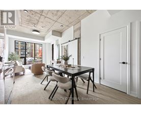 A dining room with a table set for two and a view of the street outside.