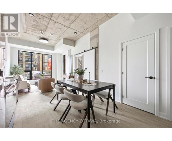 A dining room with a table set for two and a view of the street outside.