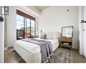 A bedroom with a large bed and a window overlooking a street.