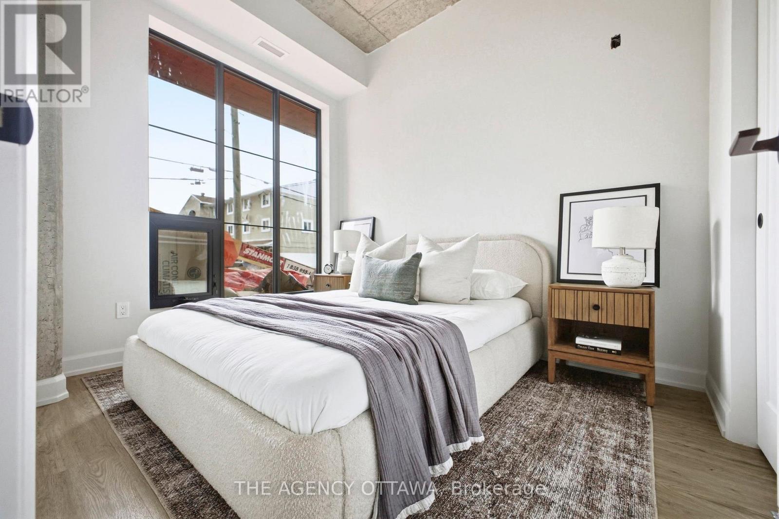 A bedroom with a large bed and a window overlooking a street.