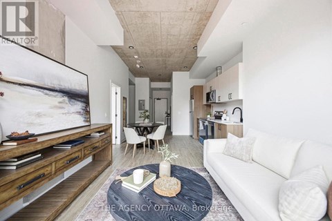 A living room with a white couch, a coffee table, and a large painting on the wall.