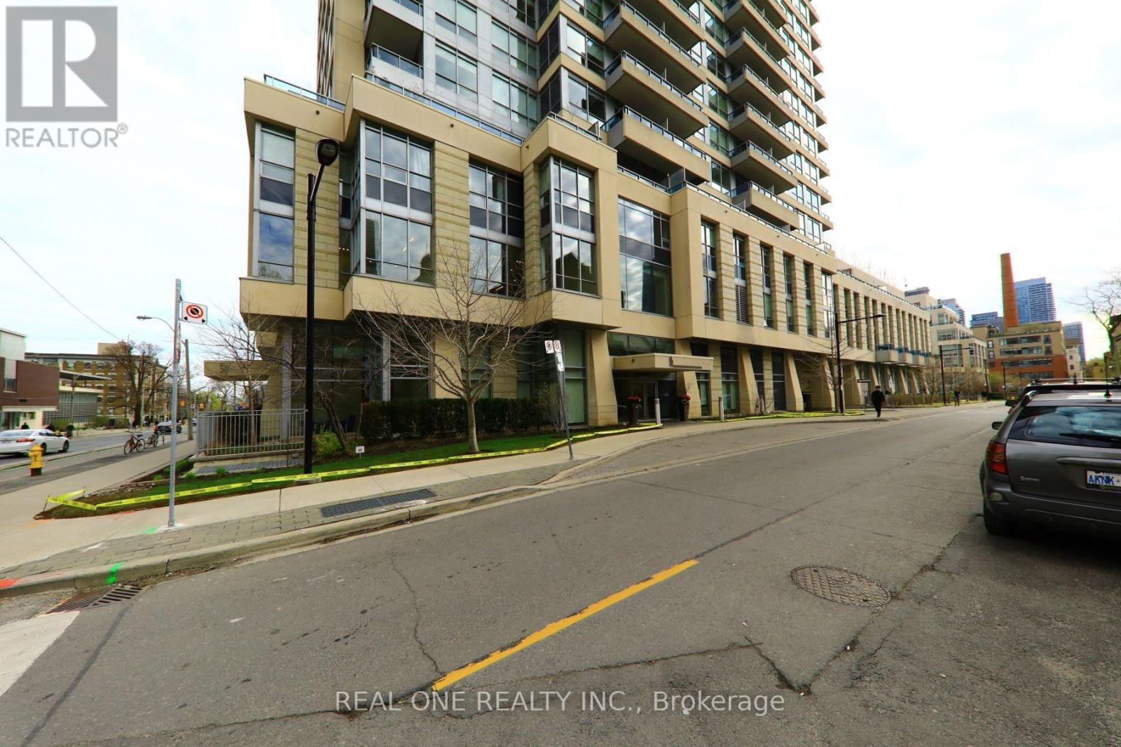 A street view of a building with the logo REAL ONE REALTY INC., Brokerage on the bottom right.