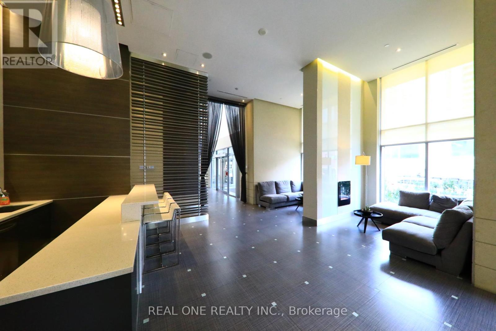 A spacious office lobby with a reception desk and a couch.