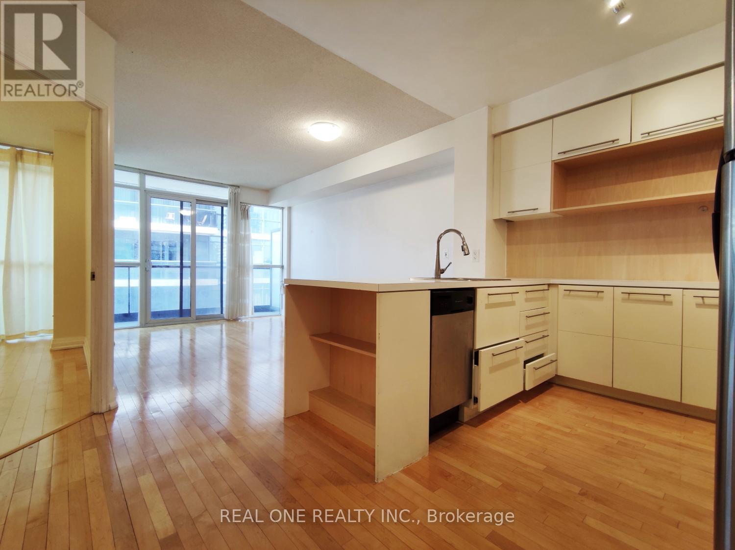 A kitchen with wooden floors and white walls.