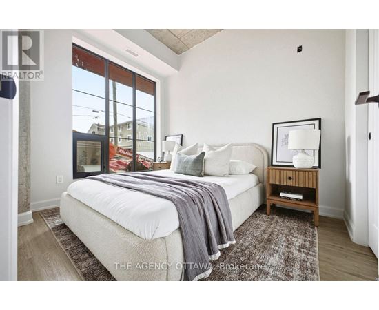 A bedroom with a large bed and a window overlooking a street.