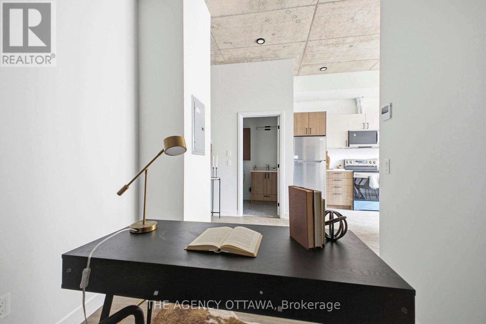 A desk with a lamp and a book on it in a room.