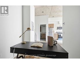 A desk with a lamp and a book on it in a room.