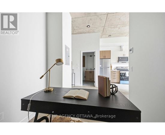 A desk with a lamp and a book on it in a room.