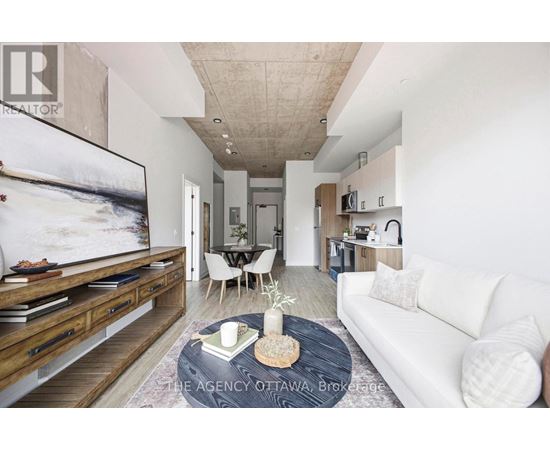 A living room with a white couch, a coffee table, and a large painting on the wall.