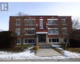 A brick building with a snow bank in front.