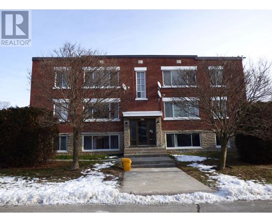 A brick building with a snow bank in front.