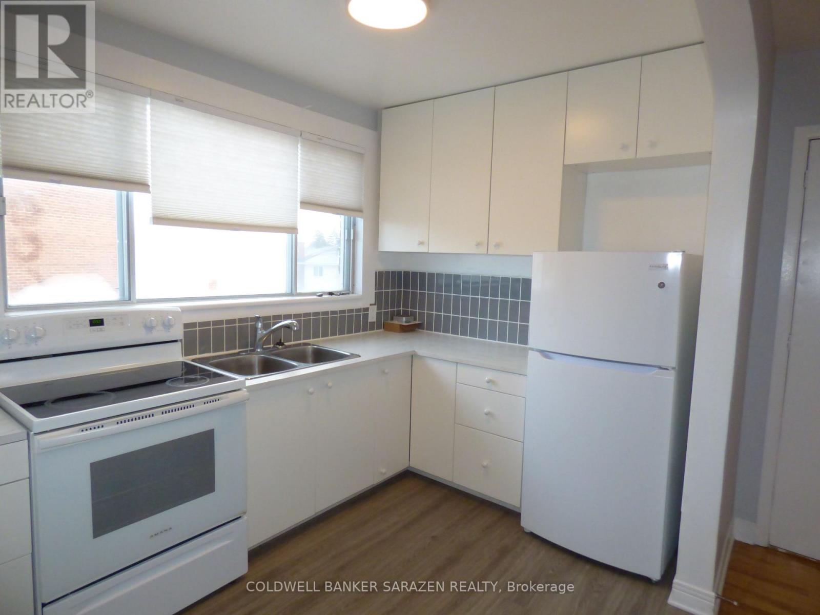 A kitchen with white appliances and cabinets.