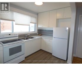 A kitchen with white appliances and cabinets.
