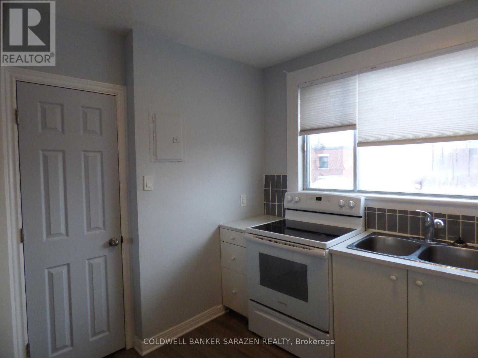 A kitchen with a stove, oven, and sink.