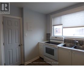 A kitchen with a stove, oven, and sink.