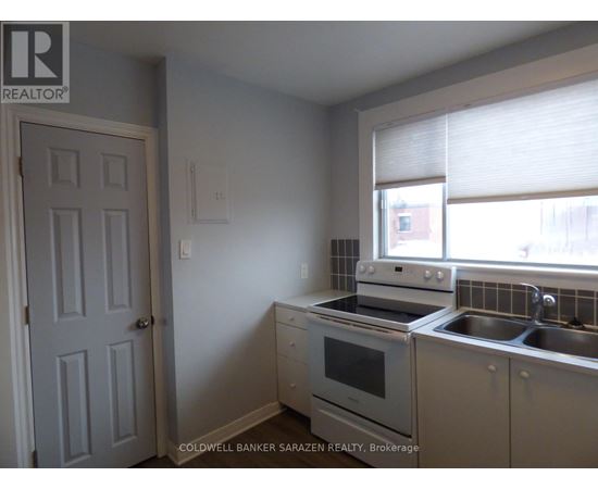 A kitchen with a stove, oven, and sink.