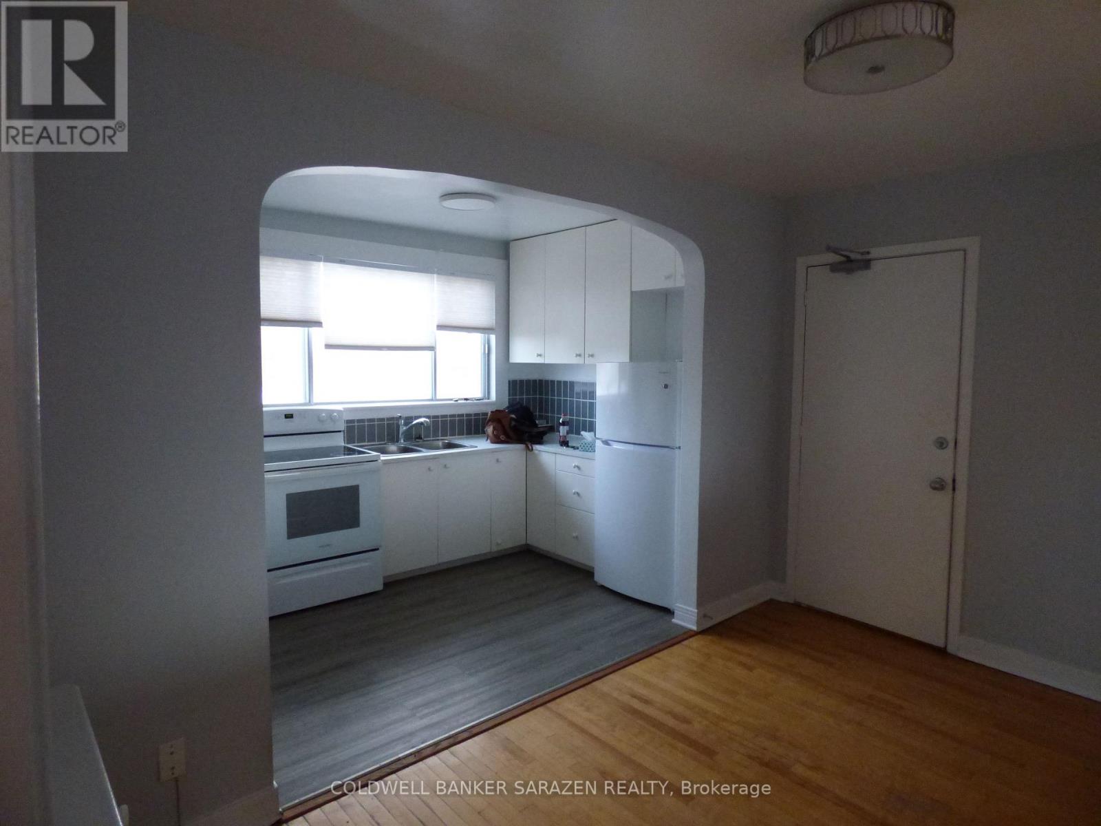 A kitchen with white cabinets and a person in the background.