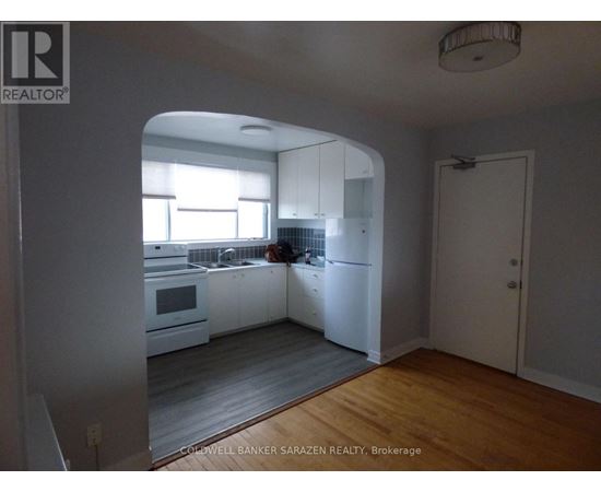 A kitchen with white cabinets and a person in the background.