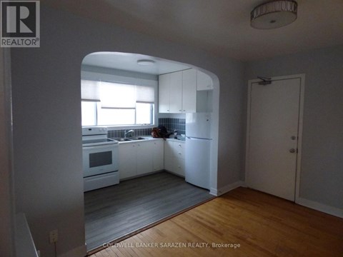 A kitchen with white cabinets and a person in the background.