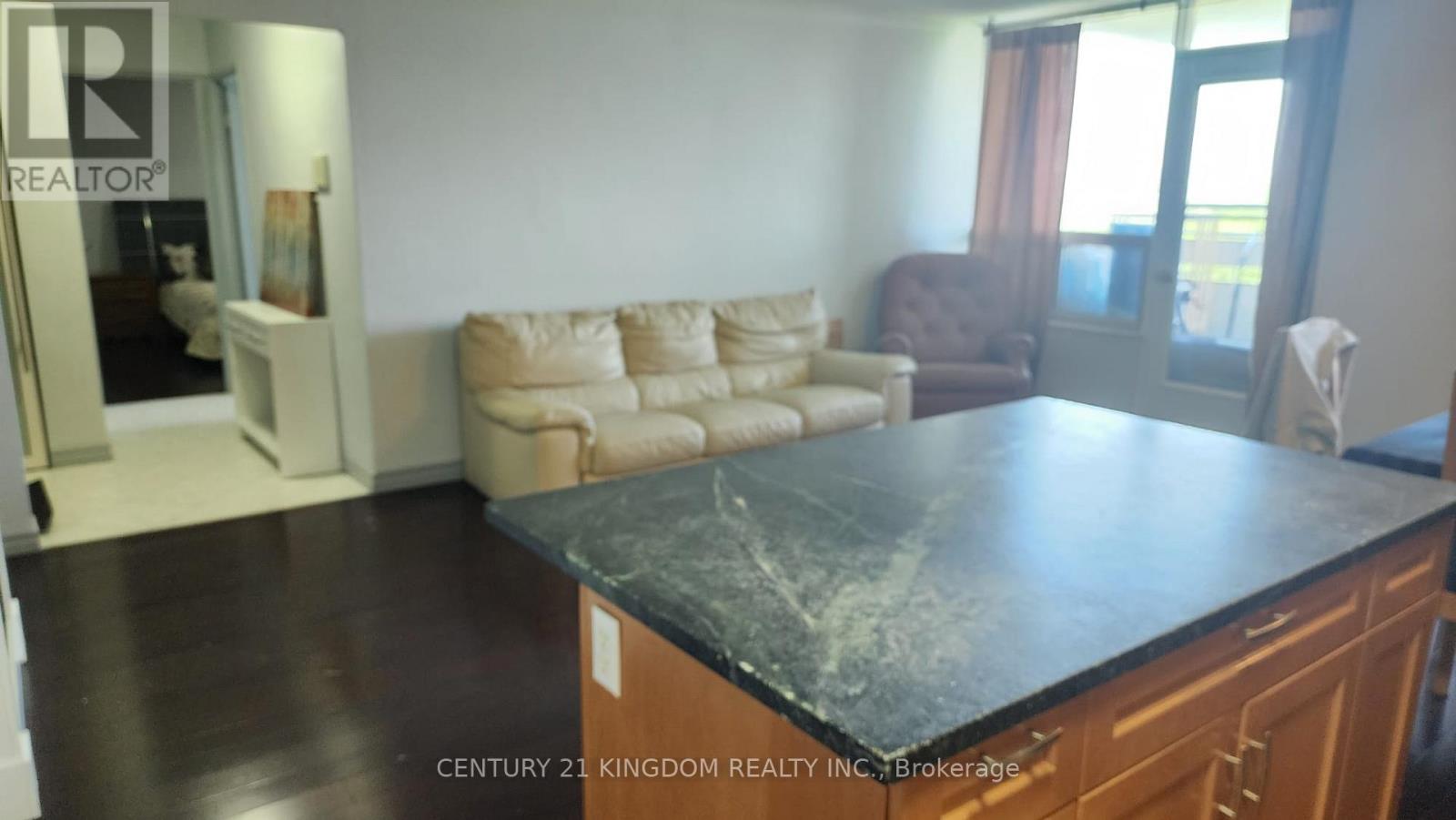 A living room with a black countertop and a brown armchair.