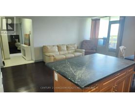 A living room with a black countertop and a brown armchair.