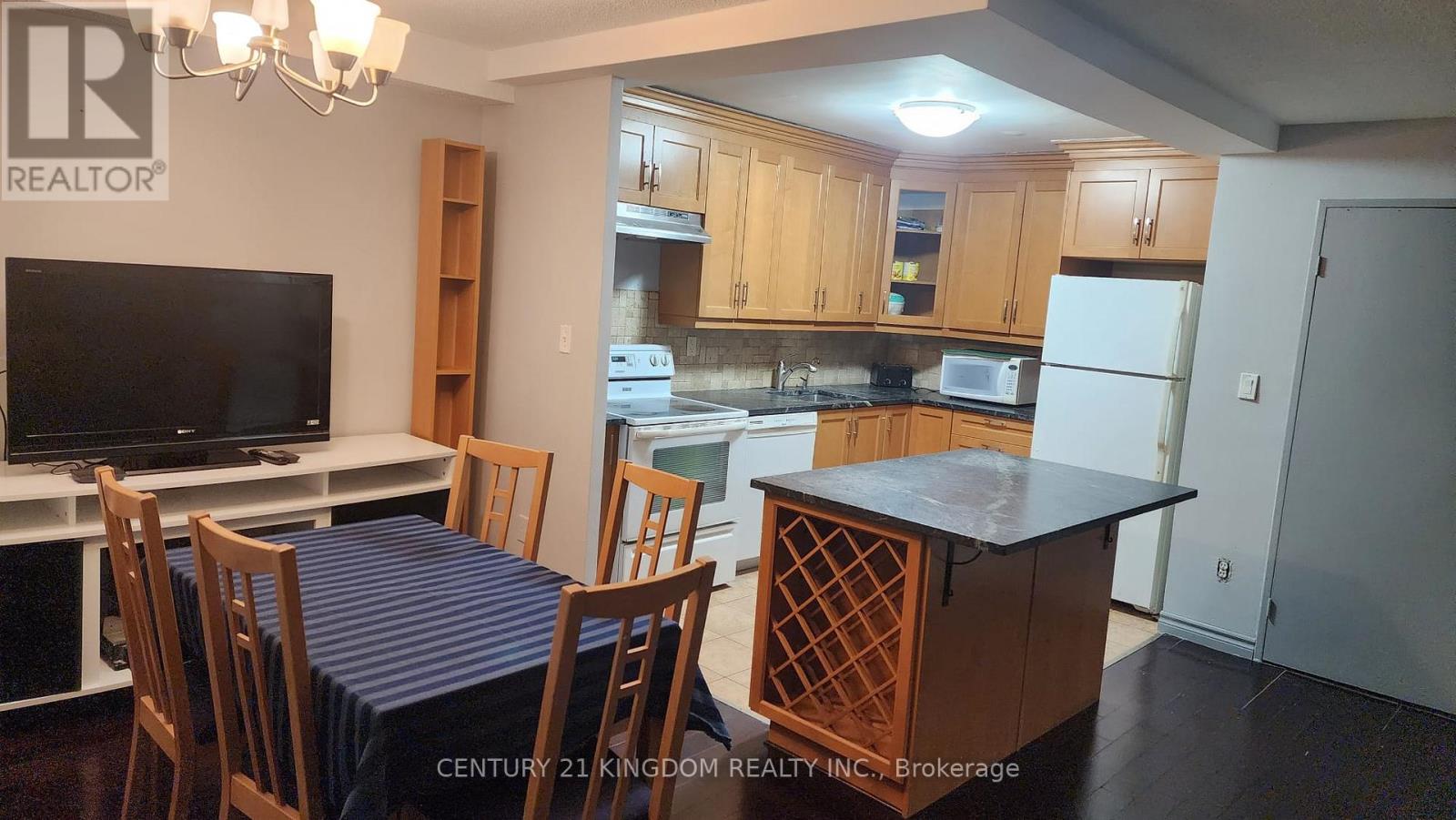 A kitchen with wooden cabinets and a dining table with chairs.