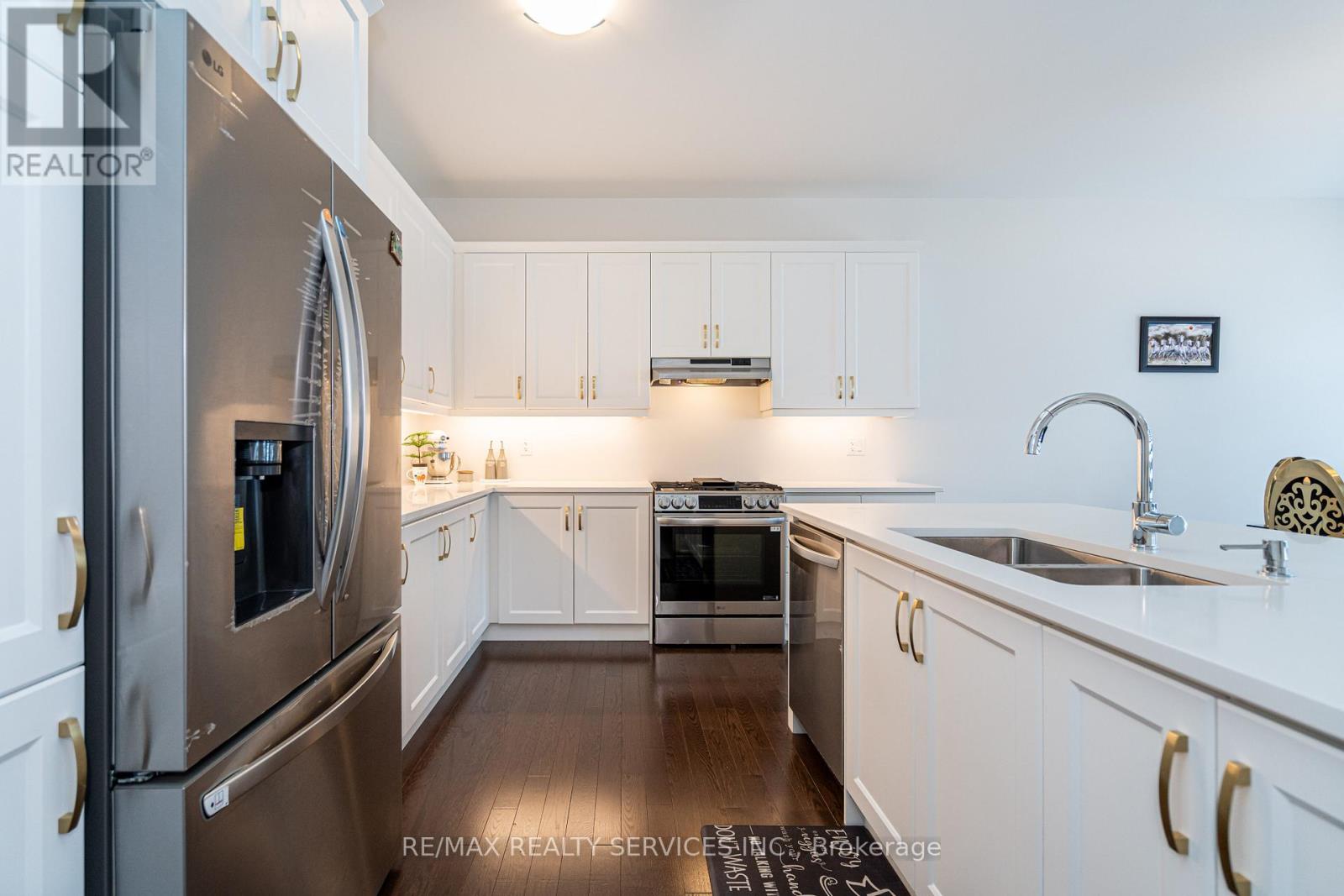 A modern kitchen with white cabinets and stainless steel appliances.