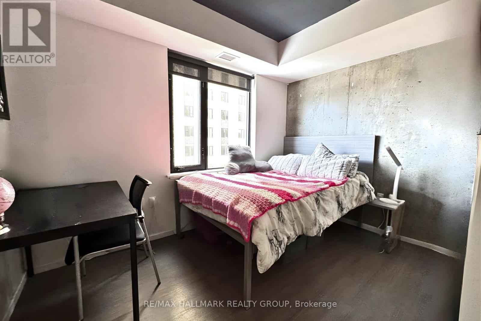 A bedroom with a bed, chair, and desk.