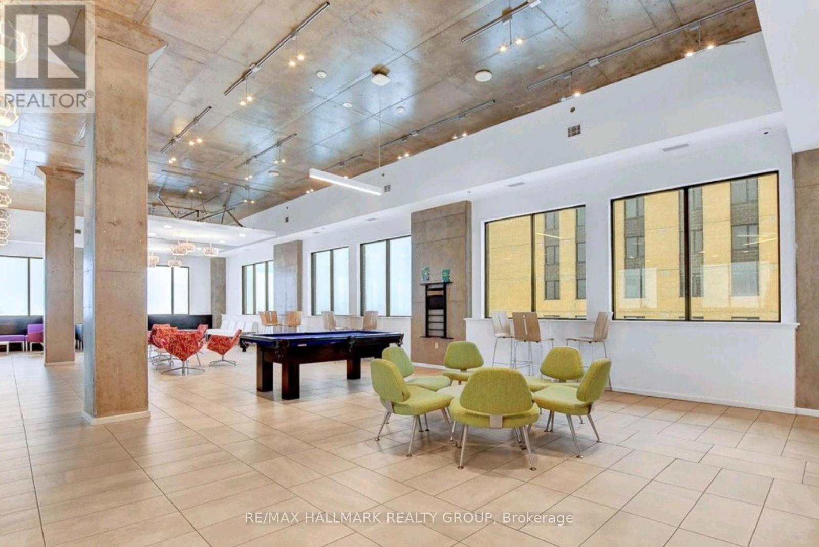 A large room with a pool table and chairs.