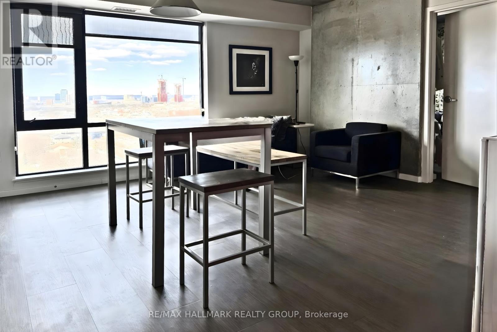 A dining area with a table and chairs in a room with a view of the city.