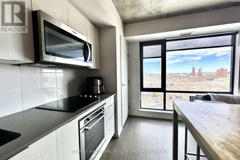 A kitchen with a microwave, oven, and stove top.