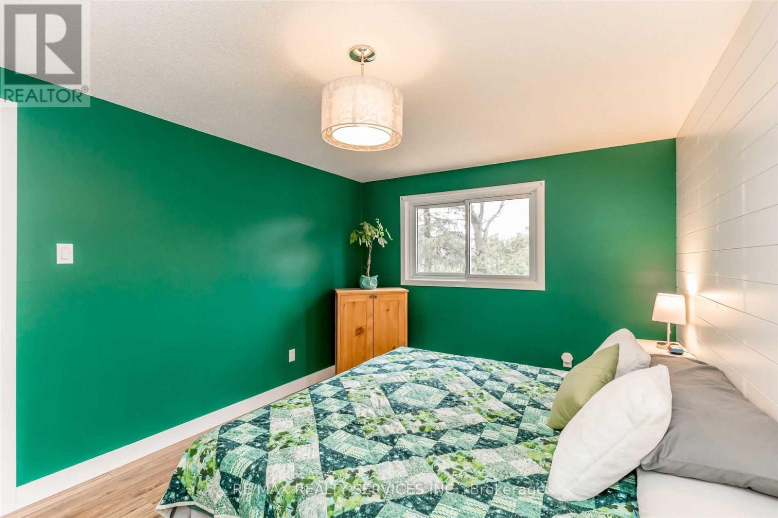 A bedroom with a bed and a green wall.
