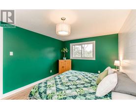 A bedroom with a bed and a green wall.