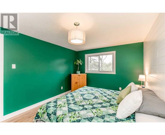 A bedroom with a bed and a green wall.
