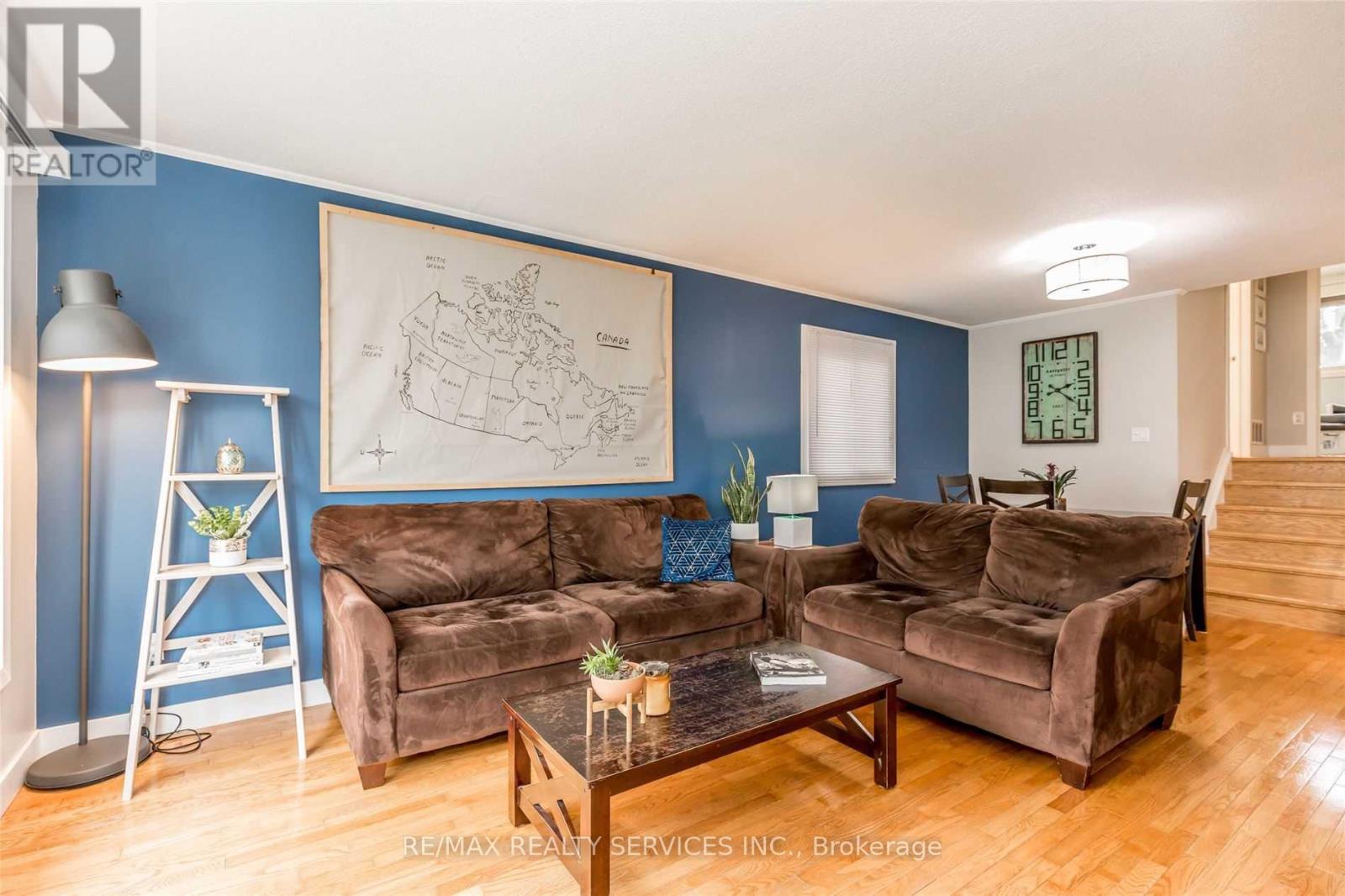 A living room with brown couches and a blue wall.