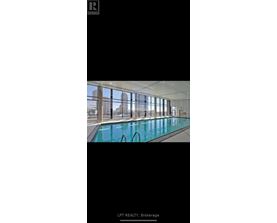 A large indoor swimming pool with a view of the city.