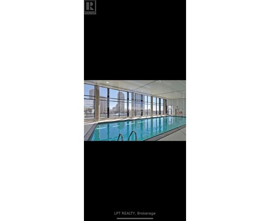 A large indoor swimming pool with a view of the city.