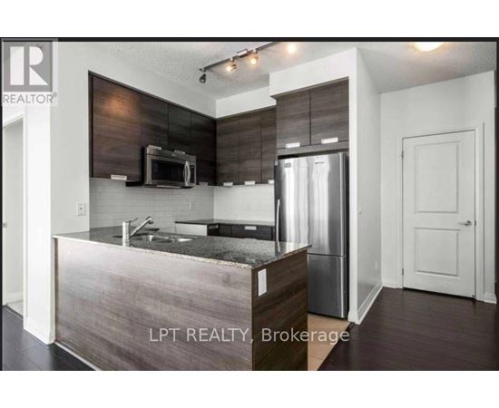 A modern kitchen with a stainless steel refrigerator and microwave.