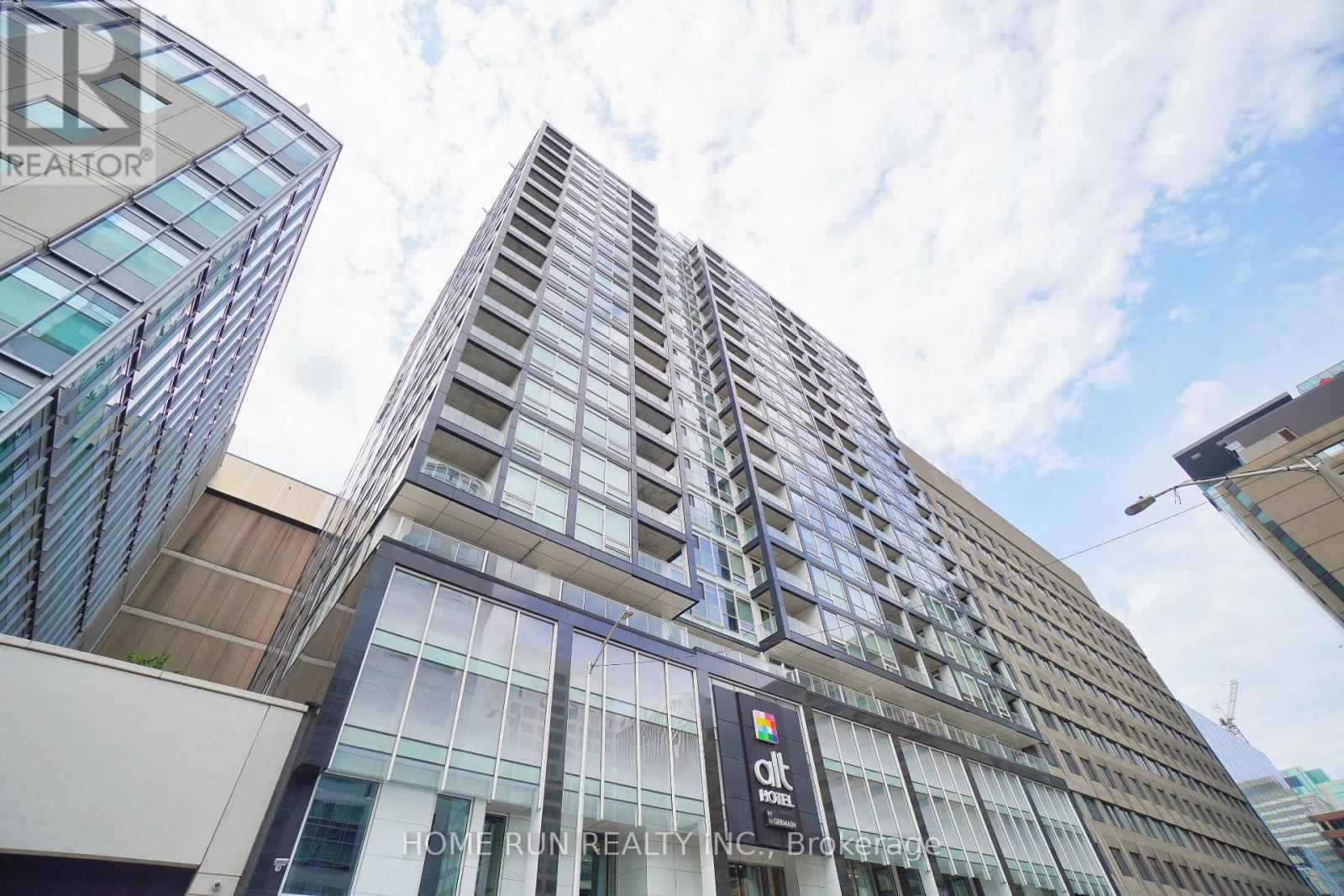 A tall building with a glass facade and a sign that reads "OIL".
