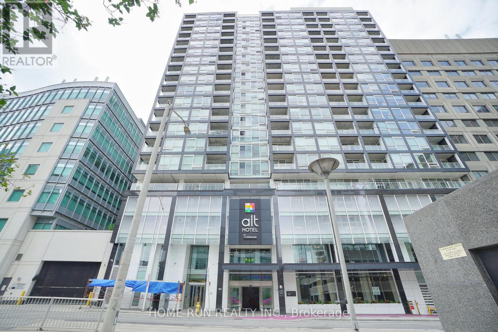 A tall building with a glass facade and a sign that reads "Quiet Hotel".
