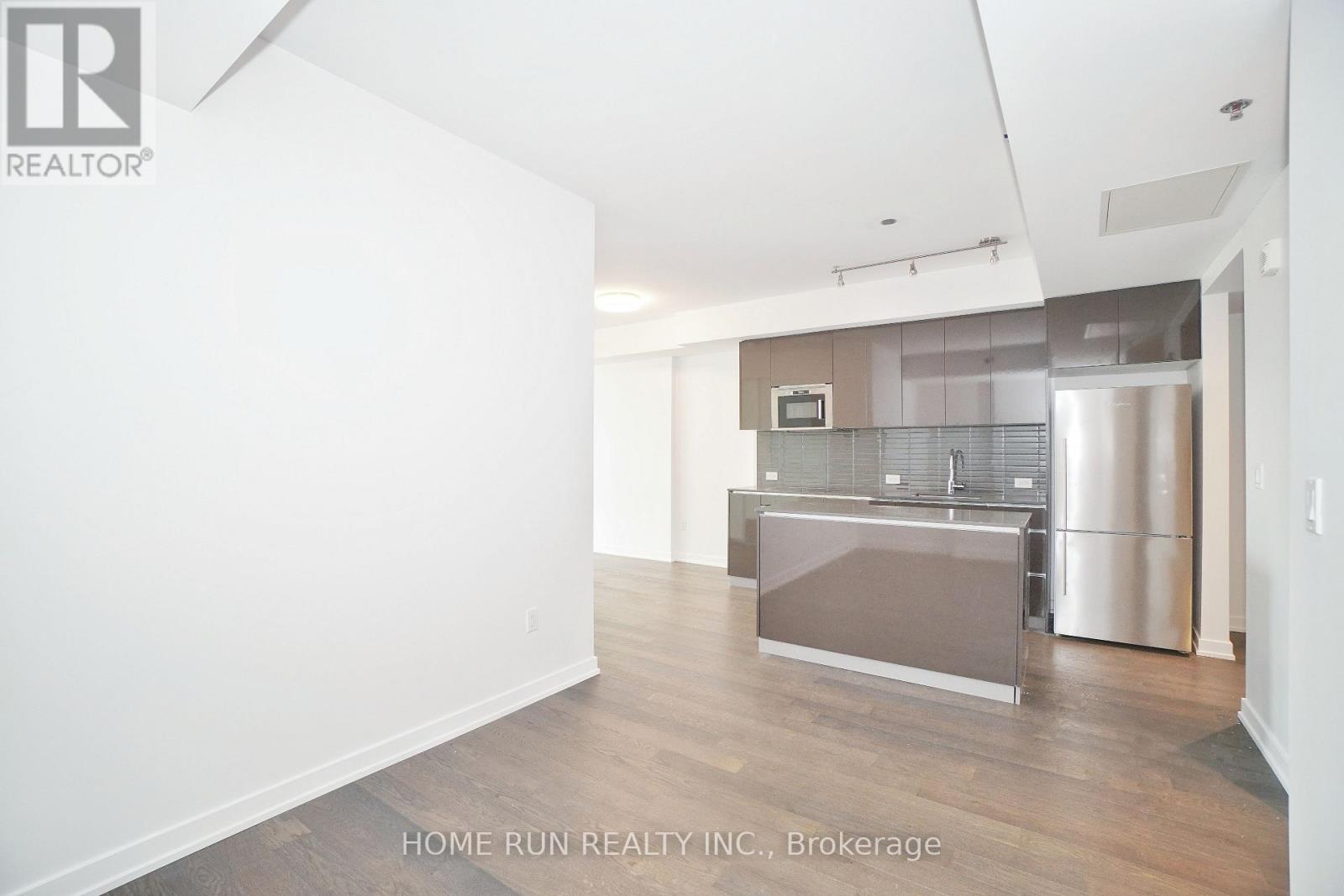 A spacious kitchen area with a refrigerator and a microwave.