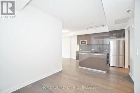 A spacious kitchen area with a refrigerator and a microwave.