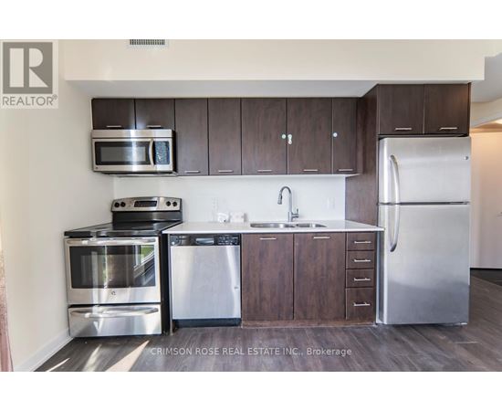 A kitchen with dark wood cabinets and stainless steel appliances.