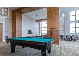 A pool table in a room with a brokerage logo.