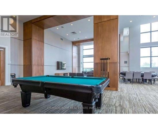 A pool table in a room with a brokerage logo.